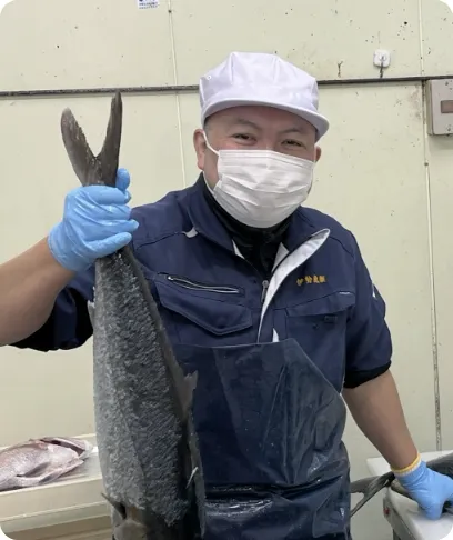 捌いた魚を持ち上げている男性